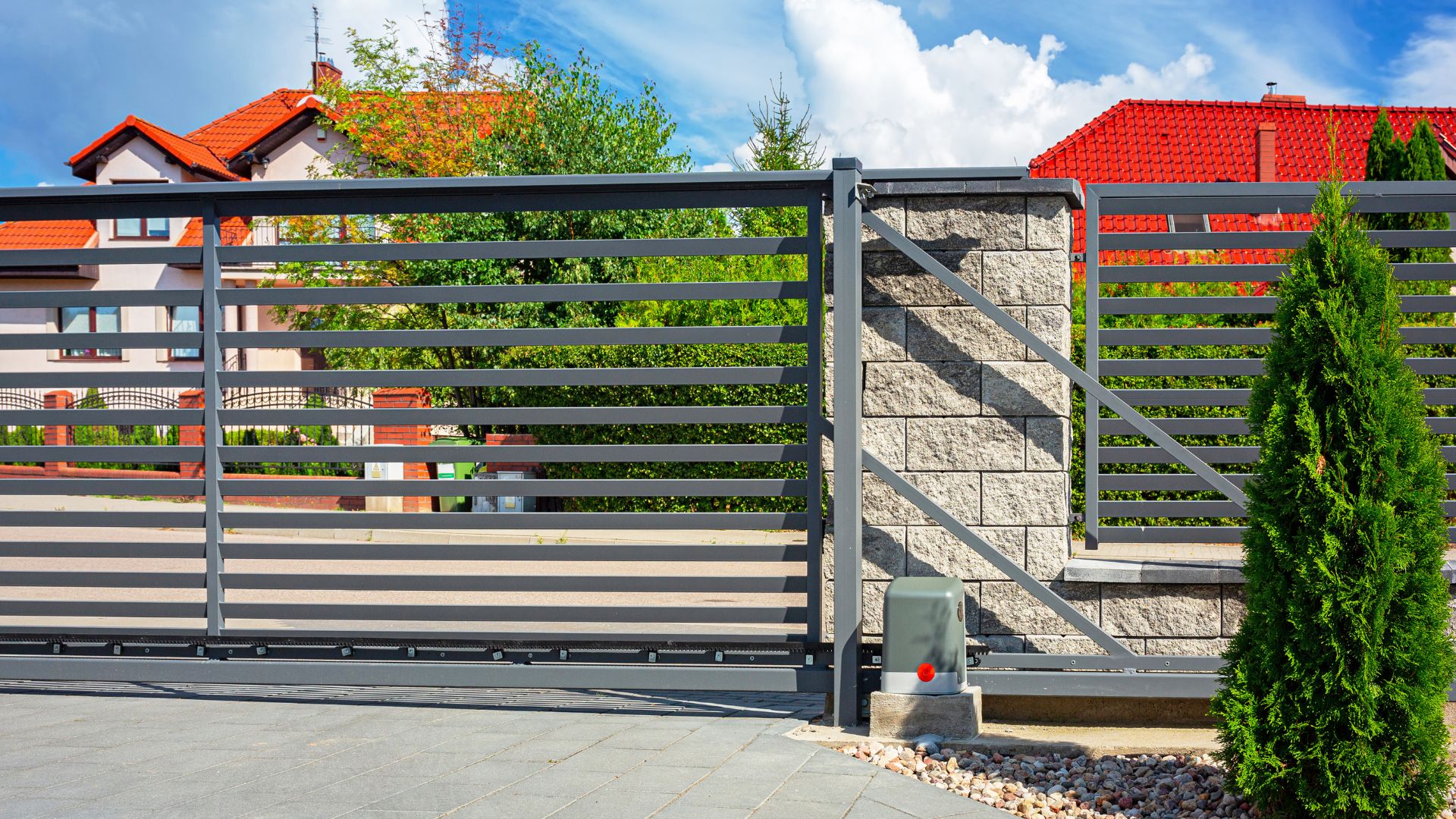 A gray automated gate in front of a beautiful home. Commercial Automatic Gates
